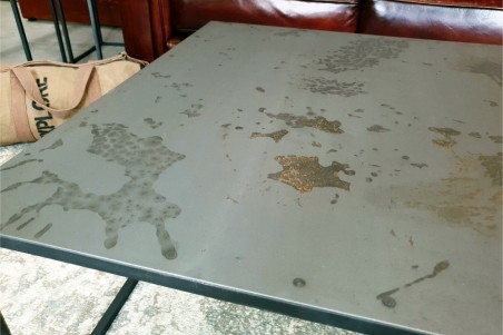 table basse carré en acier brut vernis style industriel effet marqué sur le plateau pour une déco contemporaine